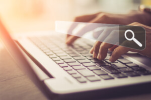 Close up of woman's hands using laptop to search online