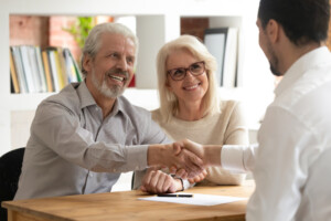 Senior couple shaking hands with loan officer