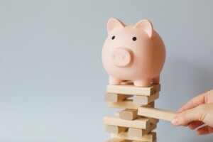 Piggy bank standing on jenga tower to represent financial stability